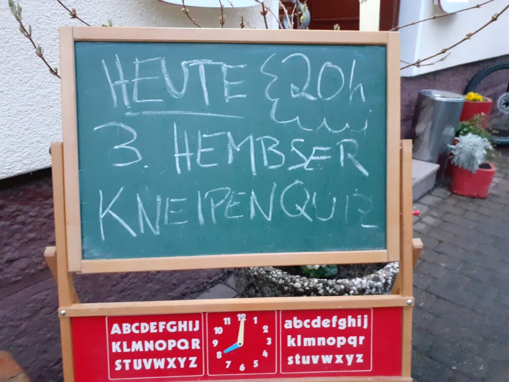 Vor dem Herzog steht eine Tafel mit der Aufschrift "Heute 20h Hembser Kneipenquiz".